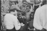 Ann Rappaport writes notes, observed by Kwiop children, Nancy Cook at left