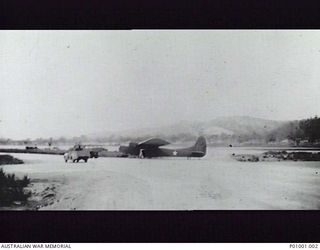 NEW GUINEA? C.1943. AN AMERICAN BUILT WACO CG-4A GLIDER AIRCRAFT WITH UNITED STATES ARMY AIR FORCE INSIGNIA, ON AN AIRFIELD WITH AN AUSTRALIAN JEEP NEARBY. (DONOR G. GRAHAM)