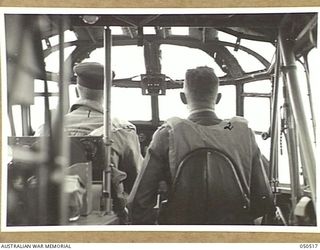 LAVERTON, VIC. 1943-04. WING COMMANDER TOWNSEND, OFFICER COMMANDING 67 SQUADRON RAAF, LEFT, PILOTING THE PLANE, AND CAPTAIN R.S. STRANAGHAN, STAFF CAPTAIN, DIRECTORATE OF SALVAGE, IN AIRCRAFT THAT ..