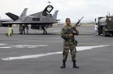 Armed with a Colt 5.56 mm M16A2 Assault Rifle, US Air Force (USAF) STAFF Sergeant (SSGT) Shawn Canionero, with the 15th Security Forces Squadron (SFS), maintains flightline security while USAF personnel from the 9th Aircraft Maintenance Squadron (AMXS) from Holloman Air Force Base (AFB), New Mexico (NM), refuel one of their F-117 Nighthawk stealth fighters at Hickam AFB, Hawaii (HI)