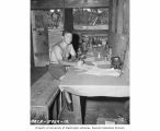 Dean Douglas M. Whitaker writing in his ledger at his biology laboratory, Bikini Island, summer 1947