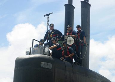 On the sail of the US Navy (USN) Los Angeles class Attack Submarine USS TUCSON (SSN 770), a navigation detail led by Commanding Officer Commander (CDR) James Pitts (center), sail their boat out of Pearl Harbor, Hawaii