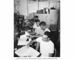 Radiochemists in the counter room on the USS CHILTON making Alpha and Beta counts on samples from Bikini Atoll, 1947