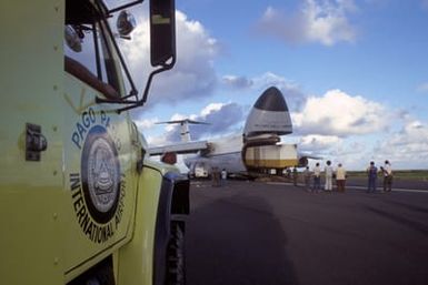 Members of the 22nd Military Airlift Squadron and local Samoans unload a tractor-trailer containing an electrical generator and supplies from the front end of a C-5 Galaxy aircraft at the Pago Pago International Airport