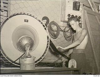 TOROKINA, BOUGAINVILLE ISLAND, SOLOMON ISLANDS. 1945-07-23. LEADING AIRCRAFTMAN RON RUSSELL OF FOOTSCRAY, VIC, USES THE DRYING MACHINE IN THE RAAF PHOTOGRAPHIC SECTION