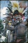 Pig festival, singsing, Kwiop: Maima and other men in red wigs and feather headdresses, at ritual fence where they will feed pork to allies