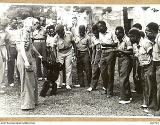 SYDNEY, NSW. 1944-01-26. AUSTRALIAN AND NEW GUINEA ADMINISTRATION UNIT NATIVES PLAYING WITH A TAME CHIMPANZEE AT THE TARONGA PARK ZOO