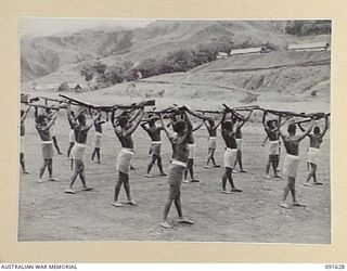 NADZAB, NEW GUINEA. 1945-05-11. NATIVE RECRUITS OF THE PACIFIC ISLANDS REGIMENT ENGAGED IN A PHYSICAL TRAINING COURSE DURING A VISIT TO THE UNIT BY GENERAL SIR THOMAS A. BLAMEY, COMMANDER-IN-CHIEF, ..