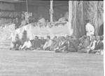 Group seated in front of royal dais