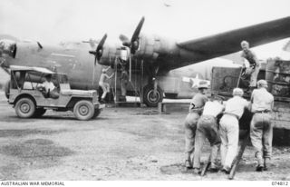 NADZAB, NEW GUINEA. 21 JULY 1944. PERSONNEL OF 39TH LINES OF COMMUNICATION SALVAGE SECTION, HEADQUARTERS, 8TH SALVAGE DEPOT, LOADING A DRUM OF USED OIL ONTO ONE OF THE UNIT TRUCKS. IDENTIFIED ..