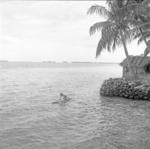 Youngster on playing on vaka ama (raft) in lagoon