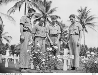 MILNE BAY, NEW GUINEA. 1943-06-27. STANDING IN MEMORY BY THE GRAVE OF THEIR FRIEND, QX36357 PRIVATE H.E. MCNEIL OF THE 61ST AUSTRALIAN INFANTRY BATTALION, WHO WAS KILLED DURING THE BATTLE FOR MILNE ..
