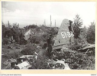 A WRECKED JAPANESE PLANE ON THE FORESHORE AT KAVIENG. AN AUSTRALIAN NEW GUINEA ADMINISTRATIVE UNIT ADMINISTRATIVE HEADQUARTERS IS BEING SET UP AT KAVIENG WITH CAPTAIN F.N.W. SHAND, ANGAU DISTRICT ..