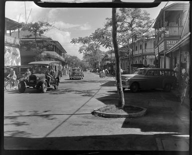 Street scene in Papeete, Tahiti, showing cars and people on bicycles