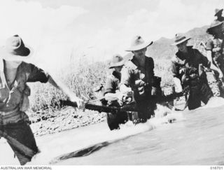 Finisterre Range, New Guinea. 22 March 1944. Troops cross a stream against a current running at eight knots on their way to Shaggy Ridge in operations recorded in the Department of Information film ..