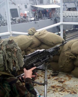 Private First Class (PFC) Macintosh USMC, assigned to L/Company, 3rd Battalion, 3rd Marine Regiment mans a 7.62mm M240G Machine Gun from a bunkered position as he provides security for the USS HOPPER (DDG 70) at Pearl Harbor, Hawaii