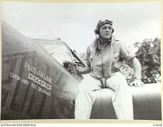 1943-04-12. NEW GUINEA. LIEUT J.H. LANE OF BAKERSFIELD, CALIFORNIA SITTING ON HIS P38 FIGHTER. THE FOUR FLAGS PAINTED ON THE SIDE INDICATE HE HAS SHOT DOWN 4 ZEROS IN NEW GUINEA. (NEGATIVE BY N. ..