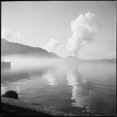 Ship and jetty and two columns of smoke rising from mountains in the distance, Rabaul Harbour, New Guinea, 1937 / Sarah Chinnery