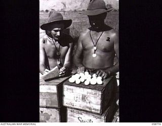 RAMU VALLEY, NEW GUINEA. 1943-10-07. SX2659 WARRANT OFFICER 2 A. P. HOWE (LEFT) AND SX2743 SERGEANT R. G. FISHER OF THE 2/2ND AUSTRALIAN SUPPLY DEPOT COMPANY, AUSTRALIAN ARMY SERVICE CORPS, 7TH ..