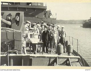 MADANG, NEW GUINEA. 1944-08/09. PETTY OFFICERS RECEIVING THEIR PAY ABOARD THE RAN CORVETTE GEELONG