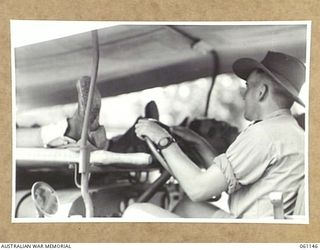 12 MILE, PORT MORESBY AREA, NEW GUINEA. 1943-12-03. NX139809 DRIVER A. F. WEATHERALL OF THE 2ND AUSTRALIAN MOTOR AMBULANCE CONVOY DEMONSTRATING A NEW JEEP AMBULANCE WHICH WAS BUILT BY THE UNIT