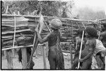 House-building for Rappaports': flattened pandanus leaves for siding being attached to frame