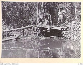 WEWAK AREA, NEW GUINEA. 1945-07-18. MEMBERS OF 2/22 FIELD PARK COMPANY, ROYAL AUSTRALIAN ENGINEERS, STANDING ON A JAPANESE BUILT LANDING STAGE, APPROXIMATELY THREE MILES UP THE URFIP CREEK, WHERE ..