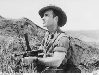 1944-03-22. NEW GUINEA. L/CPL. J.H. ADAMS (SHORTY) OF AN A.I.F. UNIT WHO ASSISTED IN MAKING THE DOCUMENTARY FILM "JUNGLE PATROL" PHOTOGRAPHED IN THE RAMU VALLEY AND FINISTERRE RANGE