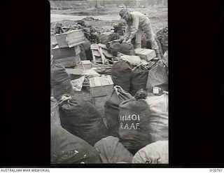 MOMOTE, LOS NEGROS ISLANDS, ADMIRALTY ISLANDS. 1944-03-08. CORPORAL V. C. THOMAS, ROSE BAY, NSW, HAS A JOB FINDING HIS GEAR AMONG THIS PILE OF STORES DUMPED ON THE BEACH, AS ONE KITBAG LOOKS MUCH ..