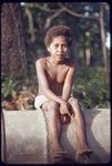 Boy sitting on an oil drum