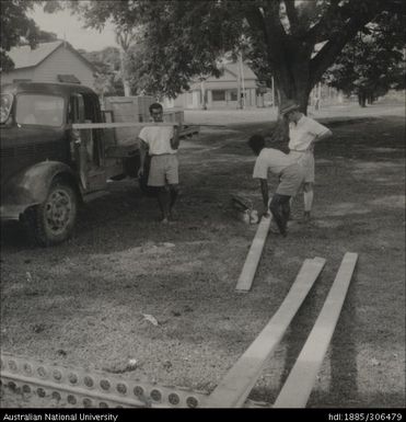 Workers moving planks of wood