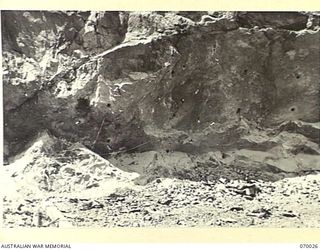 NINE MILE QUARRY AREA, PORT MORESBY, NEW GUINEA. 1944-01-22. 350 LBS OF GELIGNITE AND MONOBELL WIRED BY 12TH COMMANDER ROYAL ENGINEERS, (WORKS), (A.I.F.), PRIOR TO BLASTING A SECTION OF THE QUARRY ..