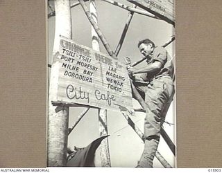 NEW GUINEA. 1943-10-02. NADZAB LANDING FIELD. NX69757 LIEUTENANT (LT) RUSSELL "RUSTY" WHITE, 2/2ND PIONEER BATTALION, AND OF LAVENDER BAY, NSW FIXES UP A SIGN POST AT THE NADZAB LANDING FIELD IN ..