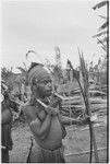 Smoking man wears sheet of paper as part of headdress, holds bow and arrows