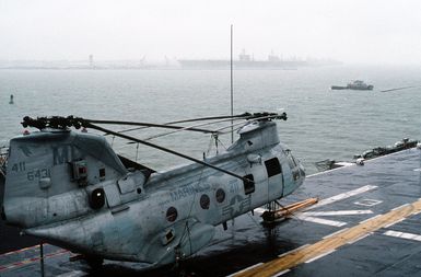 A CH-46E Sea Knight helicopter from Marine Medium Helicopter Squadron 774 (HMM-774), 4th Marine Aircraft Wing (4th MAW), sits on the flight deck of the amphibious assault ship USS GUAM (LPH-9) as the ship arrives at the naval station. The GUAM is returning to Norfolk following its deployment to the Persian Gulf region for Operation Desert Shield and Operation Desert Storm