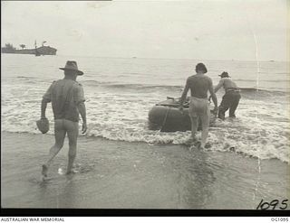 AITAPE, NORTH EAST NEW GUINEA. C. 1944-06. PILOT OFFICER A. R. BENNETT, NEDLANDS, WA, A FORMER CAPTAIN IN THE AIF, KEEPS HIS TROUSERS DRY WHEN LAUNCHING A RUBBER BOAT FOR A SOUNDING PARTY OF NO. 13 ..