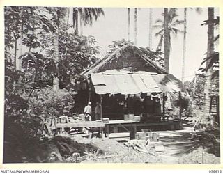 BONIS PENINSULA, BOUGAINVILLE. 1945-09-15. JAPANESE LIVING QUARTERS AT THE JAPANESE NAVAL HEADQUARTERS, BONIS PENINSULA. THE HUT, WHICH IS STILL OCCUPIED, IS CONSTRUCTED OF SAC SAC ROOFING WITH A ..