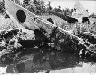 1943-01-08. PAPUA. BUNA. THIS PICTURE IS EVIDENCE OF THE ACCURACY OF ALLIED AIRMEN WHEN THEY BOMBED THE AIRSTRIP AT BUNA. PICTURE SHOWS WRECKED JAPANESE BOMBER ON THE LANDING STRIP. (NEGATIVE BY G. ..