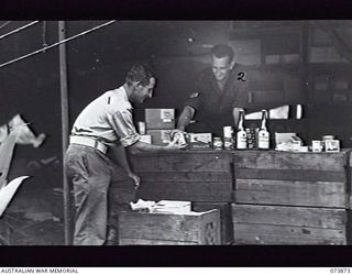 ALEXISHAFEN, NEW GUINEA. 1944-06-16. CANTEEN ISSUING POINT NO. 2, AUSTRALIAN ARMY CANTEENS SERVICE. THE UNIT IS LOCATED AT NORTH ALEXISHAFEN. VX22544 SERGEANT E. H. LEUTAS AND SX32845 CORPORAL A. ..