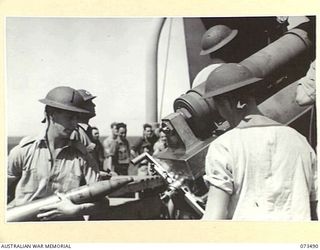 AT SEA. 1944-05-10. MEMBERS OF THE RAN LOADING THE 4 INCH GUN AT THE STERN OF THE TROOPSHIP ORMISTON DURING GUNNERY PRACTICE. THE VESSEL, HEADING FROM PORT MORESBY TO LAE, CARRIES 16 NAVAL ..