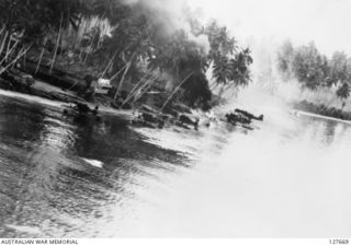 KAVIENG, NEW IRELAND. ? 1944-03. AERIAL PHOTOGRAPH OF A STRAFING RUN ON JAPANESE FLOATPLANES BY B25 MITCHELL BOMBER AIRCRAFT FROM FIFTH AIR FORCE, US ARMY AIR FORCE. ONE SHIP CAN BE SEEN ALREADY ..