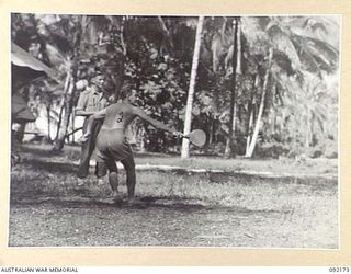 JACQUINOT BAY, NEW BRITAIN. 1945-05-18. PRIVATE J. FEENY, WELL KNOWN QUEENSLAND INTERSTATE FOOTBALLER AND CRICKETER (2), TAKING A BACKHAND STROKE DURING A GAME OF BADMINTON AT HEADQUARTERS 5 ..
