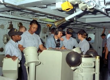 Members of the bridge crew of the submarine tender USS HOLLAND (AS-32) stand watch in the pilot house as the ship departs Guam on a 45 day cruise which will include a stop over at Sasebo, Japan