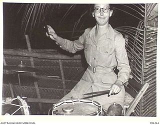 PALMALMAL PLANTATION, JACQUINOT BAY, NEW BRITAIN. 1945-07-17. PRIVATE J. RUMLLS, AUSTRALIAN ARMY MEDICAL WOMEN'S SERVICE, TAKING A TURN ON THE BAND'S DRUMS DURING INTERVAL AT A SPECIAL DANCE HELD ..