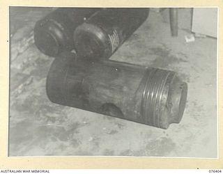 LABU, NEW GUINEA. 1944-10-03. ONE OF THE BADLY WORN PISTONS OF THE MOTOR VESSEL, "FRANCES PEAT" BEFORE BEING REGROUND IN THE WORKSHOP OF THE 1ST WATERCRAFT WORKSHOP, THE "FRANCES PEAT" WAS A ..