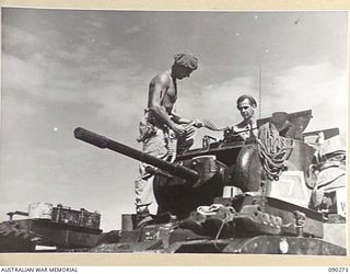 BOUGAINVILLE. 1945-03-30. B SQUADRON, 2/4 ARMOURED REGIMENT PERSONNEL LOADING SMALL ARMS AMMUNITION INTO THE TURRET OF A MATILDA TANK PRIOR TO THE MOVE FORWARD TO TOKO. 25 INFANTRY BATTALION ARE ..