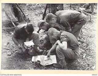 ULUNKOHOITU, YAMIL AREA, NEW GUINEA, 1945-07-18. PTE L.J. FORD (1) AND SGT J.A. MCNOUGHTON (2) WITH MEMBERS OF A COMPANY, 2/6 INFANTRY BATTALION EXAMINING A MAP. THE PLATOON OCCUPIED THE FORWARD ..