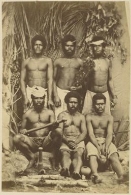 Group portrait of six indigenous New Caledonian men with Kanak artefacts, New Caledonia, ca. 1870 / photographed by W. & E. Dufty