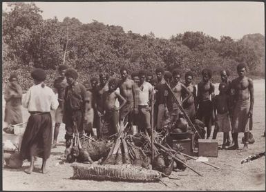 People standing with food supplies for the Southern Cross on beach of Lakona Bay, Santa Maria, Banks Islands, 1906 / J.W. Beattie