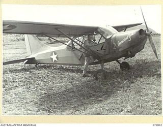 SALAMAUA, NEW GUINEA. 1944-04-30. Q14251 CAPTAIN N. R. WILDE, AUSTRALIAN NEW GUINEA ADMINISTRATIVE UNIT, LIAISON OFFICER ATTACHED TO 54TH TROOP CARRIER WING, UNITED STATES ARMY AIR FORCE, ALONGSIDE ..